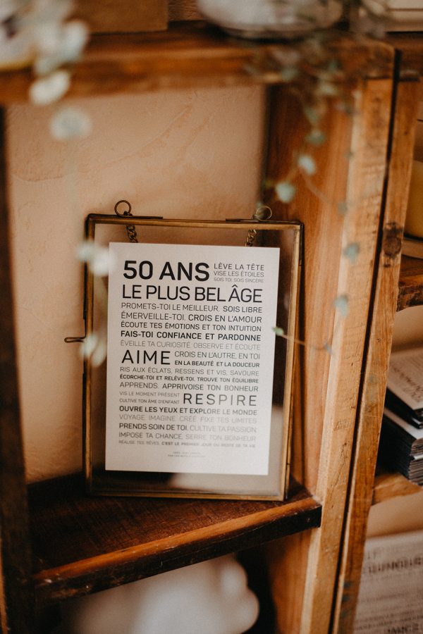 Une affiche 50 ans encadrée avec une citation, un cadeau parfait, sur une étagère.