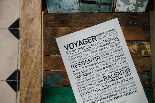 Une affiche du Voyager posée sur une table en bois.