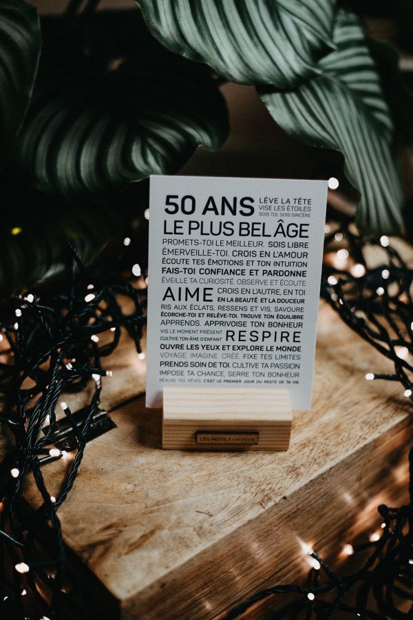 Une pancarte en bois avec les mots "50 ans" et la fleur de lys, un cadeau parfait.