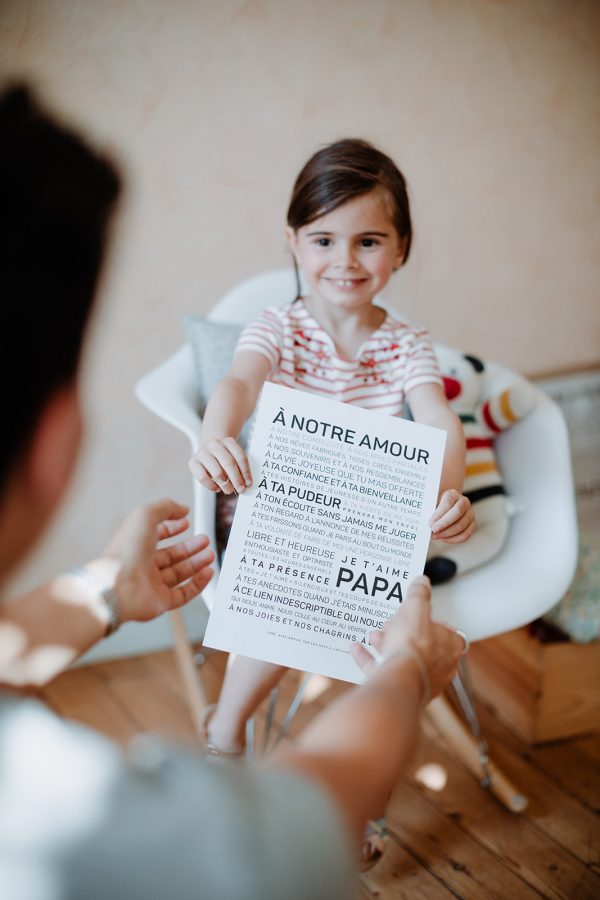 Un homme tenant un papa et un morceau de papier à une petite fille.