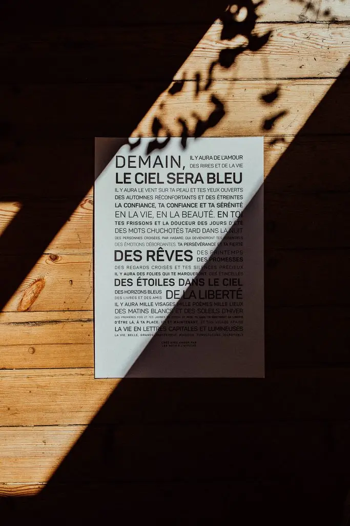Une affiche sur un parquet avec le soleil qui brille dessus.