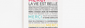 Une affiche Merci, la vie est belle (encouragements) avec les mots « miséricorde » dans différentes langues accrochée à un mur.