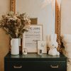 Une chambre avec une commode verte et un miroir.
