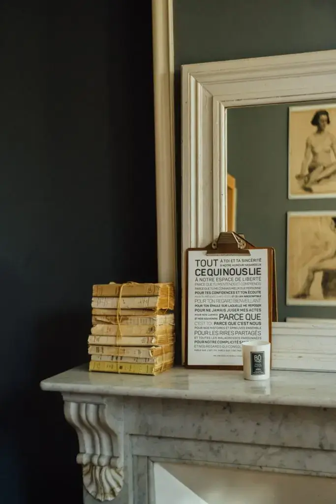 Un miroir avec une pancarte et une pile de livres.