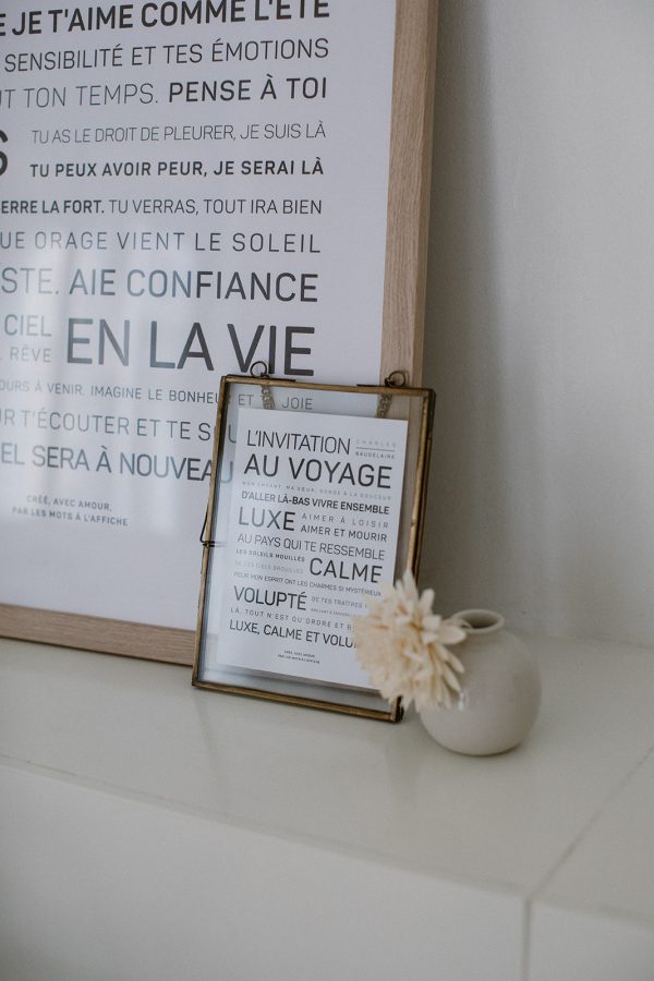Une affiche encadrée Luxe, calme et volupté - Charles Baudelaire avec des mots français dessus à côté d'un vase, un cadeau parfait.