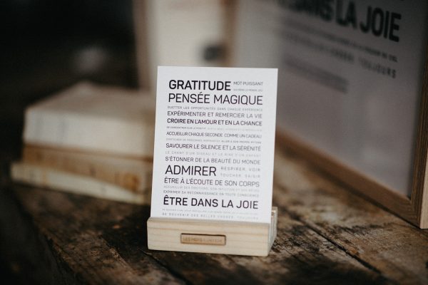 Une carte de gratitude avec un message posé sur une table en bois.