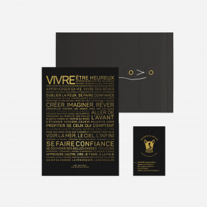 Une carte de visite noire et dorée avec le mot "Letter press : Vivre", un cadeau parfait.