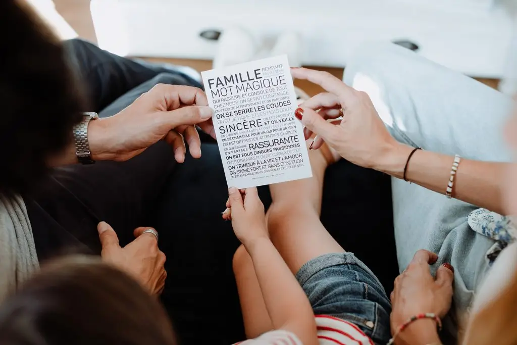 Une famille assise sur un canapé lisant un document de planification familiale en guise de cadeau.