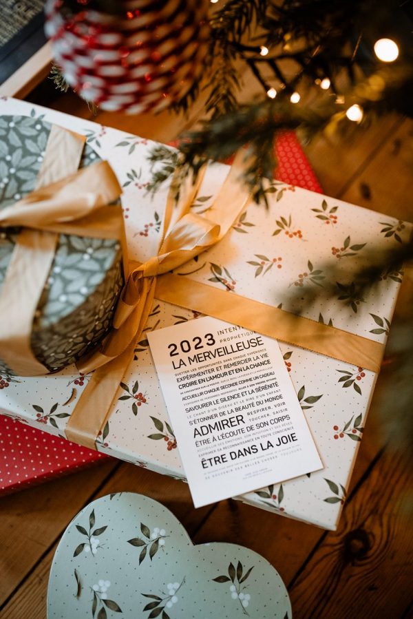 Une idée de cadeau est posée sur une table à côté d'un arbre de Noël 2024, la merveilleuse.