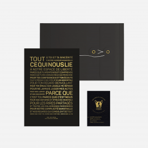 Une enveloppe noire et dorée avec un logo noir et doré, parfaite pour contenir un cadeau spécial.