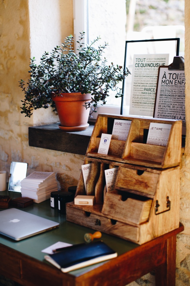 Un bureau avec un ordinateur portable et une plante "idée cadeau" dessus.