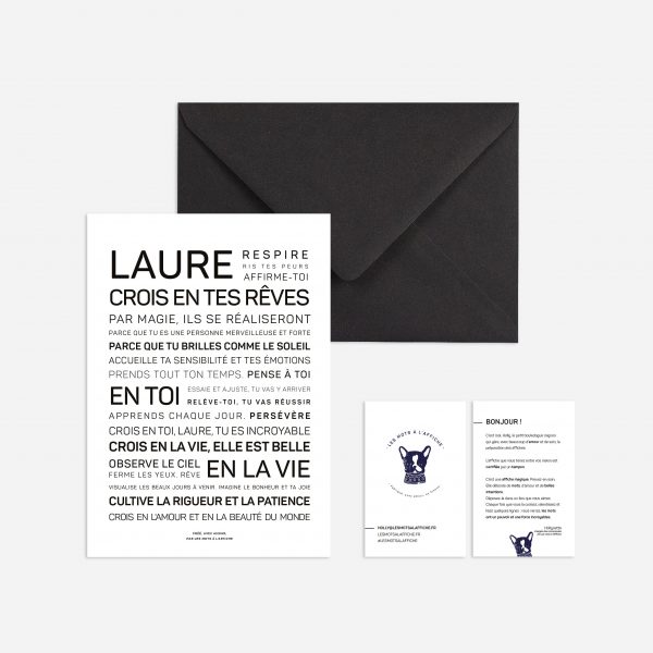 Une enveloppe noire avec le mot "Laure" dessus, contenant un cadeau.