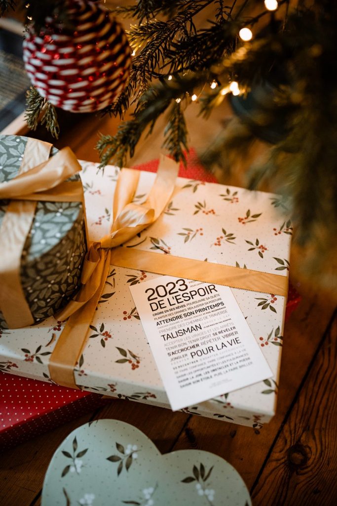 Une idée de cadeau est posée sur une table à côté d'un arbre de Noël, 2024, de l'espoir.