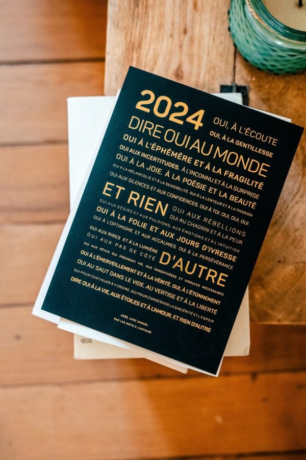 Une presse typographique : 2024 avec les mots "dire oui au monde" posés sur une table, présentant une idée poétique.