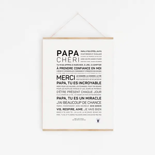 Une affiche blanche "Papa chéri" comportant un texte français en caractères noirs, exprimant la gratitude et l'admiration pour un père, est affichée sur un mur blanc et suspendue par une ficelle.