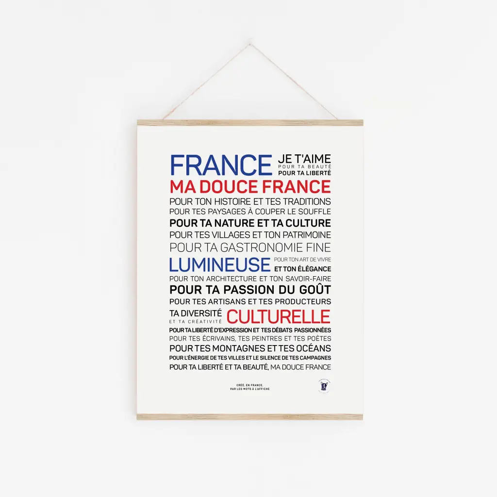 L'affiche « Douce France (couleurs) » présente un texte français en bleu, rouge et noir célébrant la culture, la nature, la gastronomie, le patrimoine et la créativité de la France - une idée cadeau parfaite - affichée sur un mur blanc dans un simple cadre en bois.