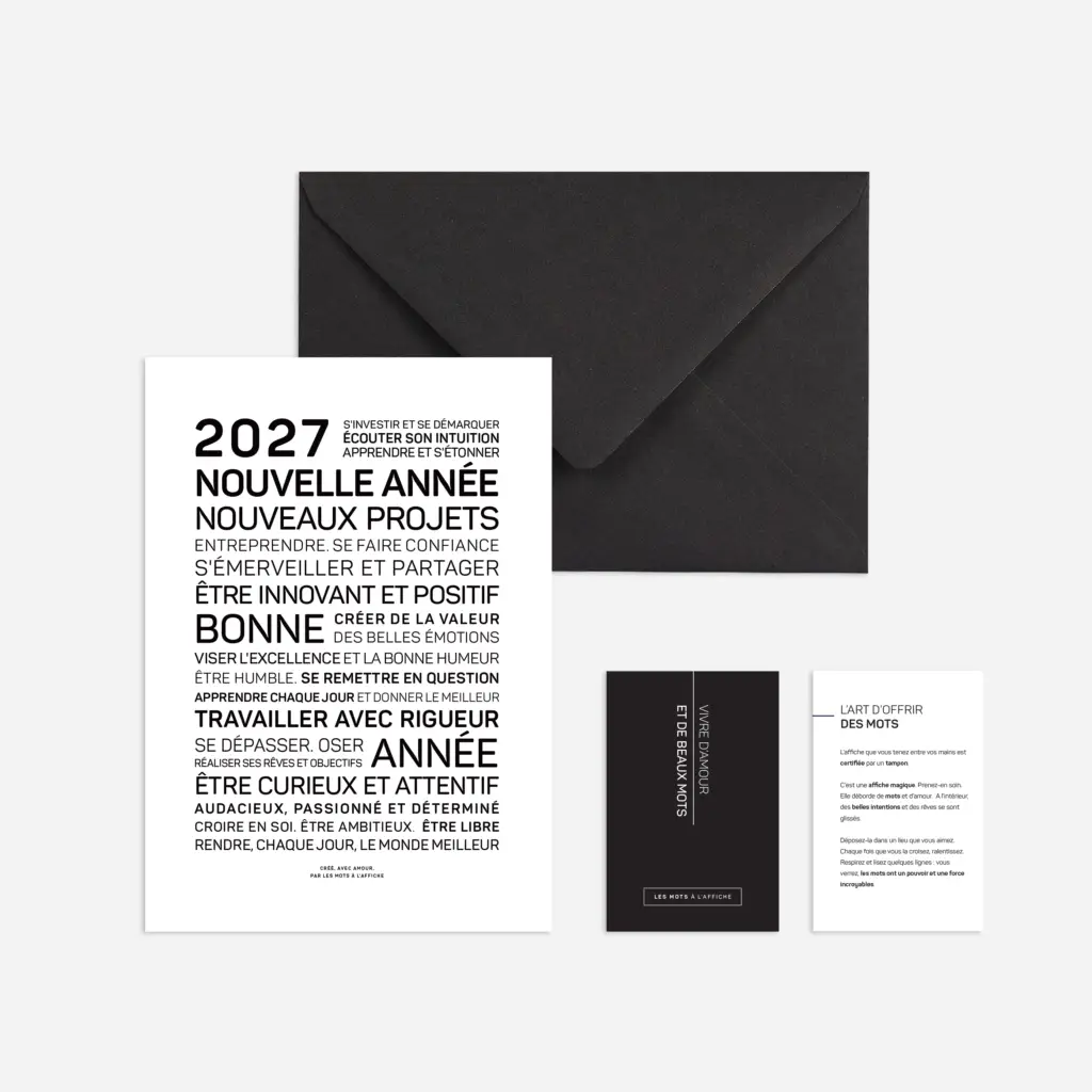 Une enveloppe noire contenant trois cartes en noir et blanc ; la plus grande carte présente des mots et des expressions en français concernant l'année 2026, les rêves, les nouveaux projets, la positivité, la créativité et l'épanouissement personnel.