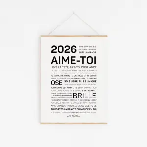 L'affiche minimaliste "2026, aime-toi" présente un texte de motivation en français en caractères gras et réguliers, centré sur un fond blanc et affiché sur un mur.