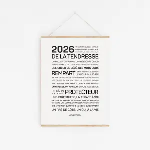 Une affiche minimaliste est accrochée à un mur blanc avec le titre "2026, aime-toi" en gras, suivi d'un texte en français dans différentes tailles de caractères.