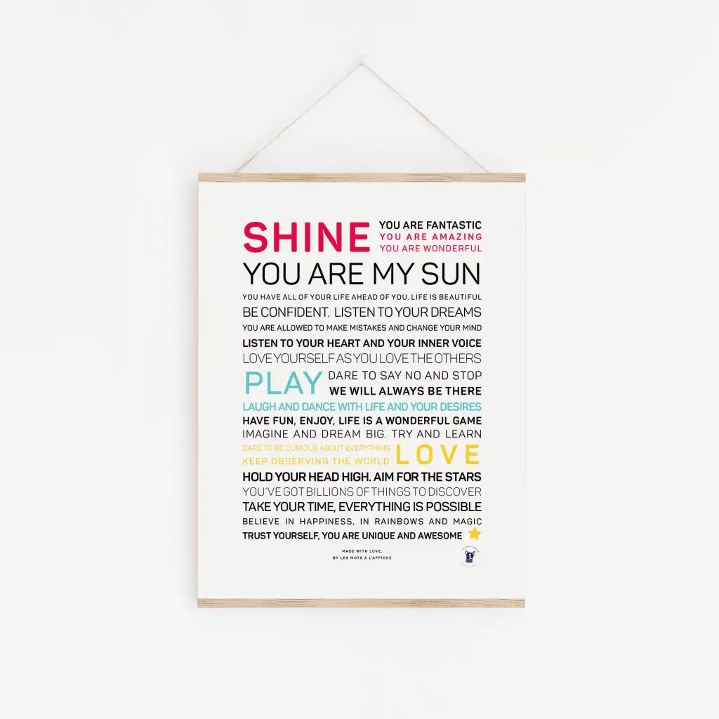 L'affiche « Shine, you are my sun » est accrochée sur un mur blanc avec des mots colorés et inspirants comme « SHINE », « PLAY », « LOVE » et « DREAM BIG » — un cadeau unique parfait ou une affiche décorative pour n'importe quel espace.