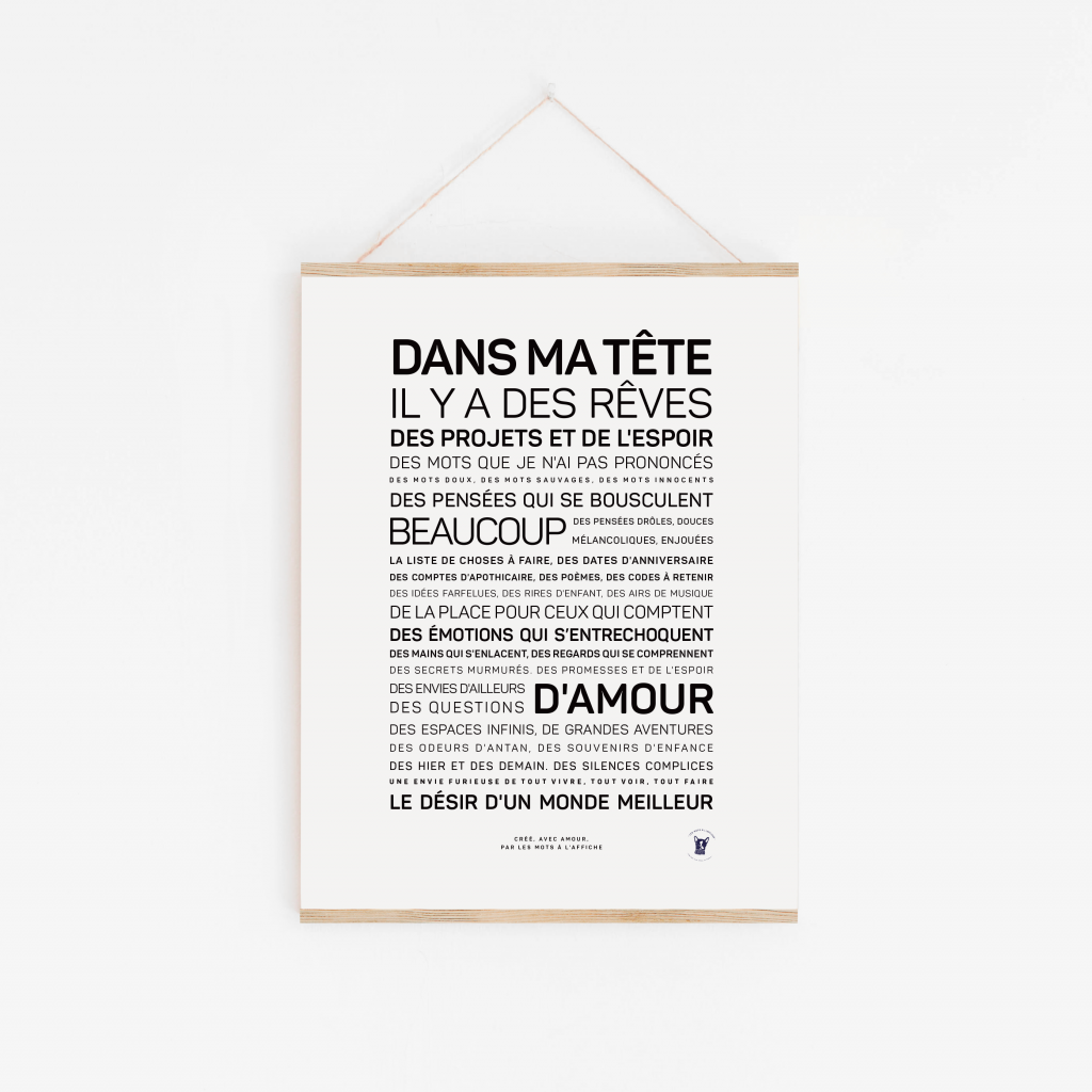 Une affiche encadrée avec le texte français « Dans ma tête, il y a... » est accrochée sur un mur blanc, affichant des mots inspirants sur les rêves et les espoirs dans des polices variées - une idée cadeau originale pour toute occasion.