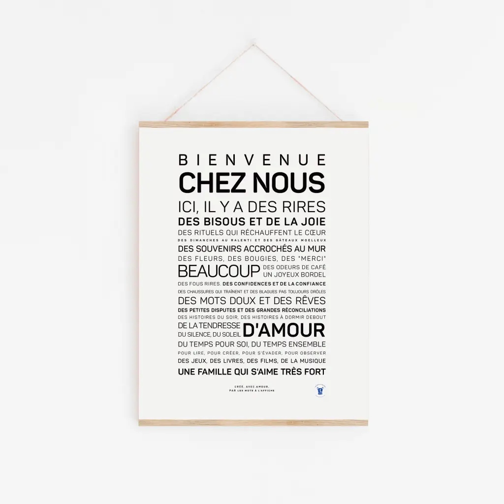 « Bienvenue à la maison » – Une affiche blanche avec un texte français noir, accrochée à un fil sur un mur blanc, accueille les invités et décrit un foyer chaleureux et joyeux. Idéale comme idée cadeau pour toutes les occasions.