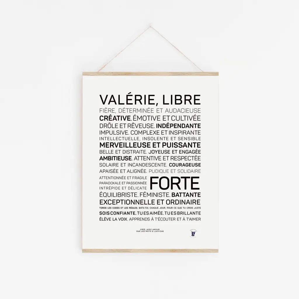 Une affiche minimaliste, « Valérie, tu es libre et forte », est accrochée sur un mur blanc avec des mots français noirs et gras énumérant des qualités stimulantes - un cadeau inspirant pour toute occasion.