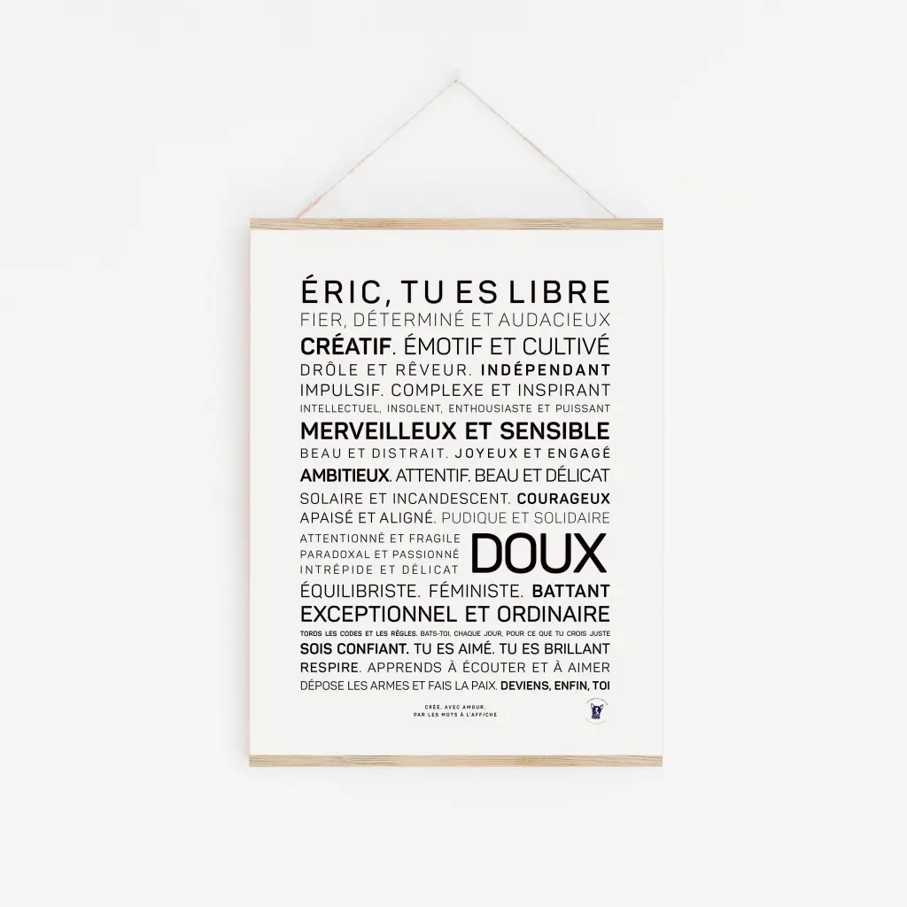 « Éric, tu es libre et doux » : une affiche blanche avec des mots de motivation en français, en noir, mettant en avant la créativité, l'indépendance, la sensibilité et la confiance. Une idée cadeau inspirante, affichée sur un mur blanc dans un cadre en bois.