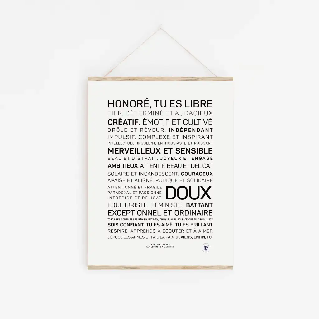 Une affiche blanche intitulée « Honoré, tu es libre et doux », comportant des mots de motivation français dans des polices variées, est accrochée au mur dans un cadre en bois avec une ficelle - une idée cadeau chic pour tout décor.