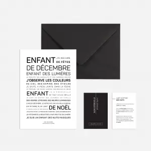 Enfant d'août est un set de papeterie noir et blanc comprenant une carte française, une enveloppe noire et deux petites cartes, le tout disposé proprement sur un fond clair.