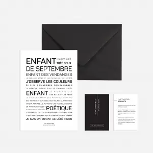 Une enveloppe noire avec une carte blanche minimale comportant un texte français en gras - Enfant d'août - accompagnée de deux cartes noires et blanches plus petites, le tout présenté sur un fond clair.