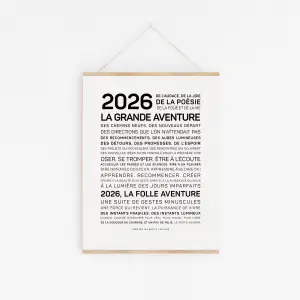 L'affiche "2026, l'aventure" présente un texte français en gras et en noir sur l'aventure et la poésie, centré sur un fond blanc et suspendu par une fine ficelle pour un aspect minimaliste.