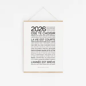 L'affiche minimaliste "2026, ose te choisir" est accrochée à un mur blanc, affichant en noir un texte de motivation en français sur la vie, les choix et la prise de risques.