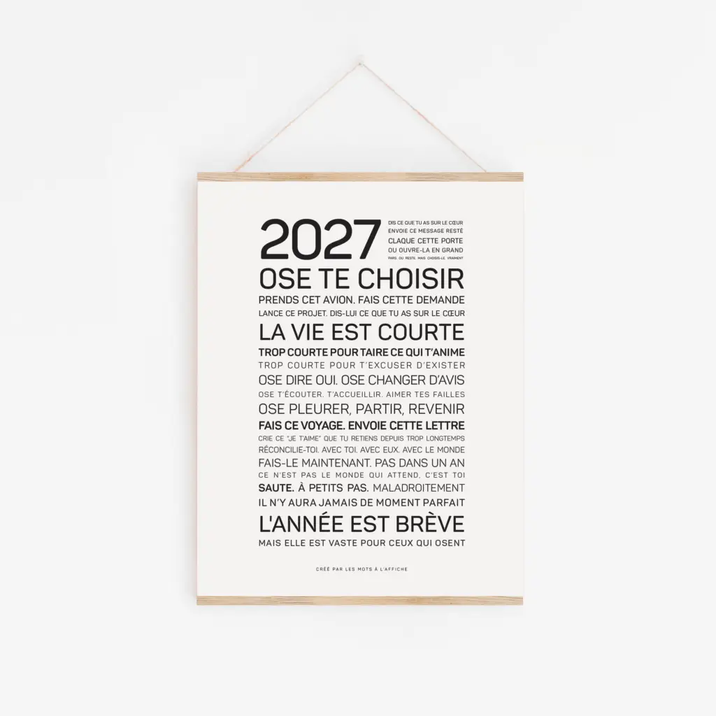 Cette décoration murale minimaliste intitulée « 2026, bonne année » présente un texte motivant en français, écrit en caractères noirs et centré sur un fond blanc, avec l'année 2026 en grands chiffres en haut et un cadre en bois muni d'une ficelle de suspension.