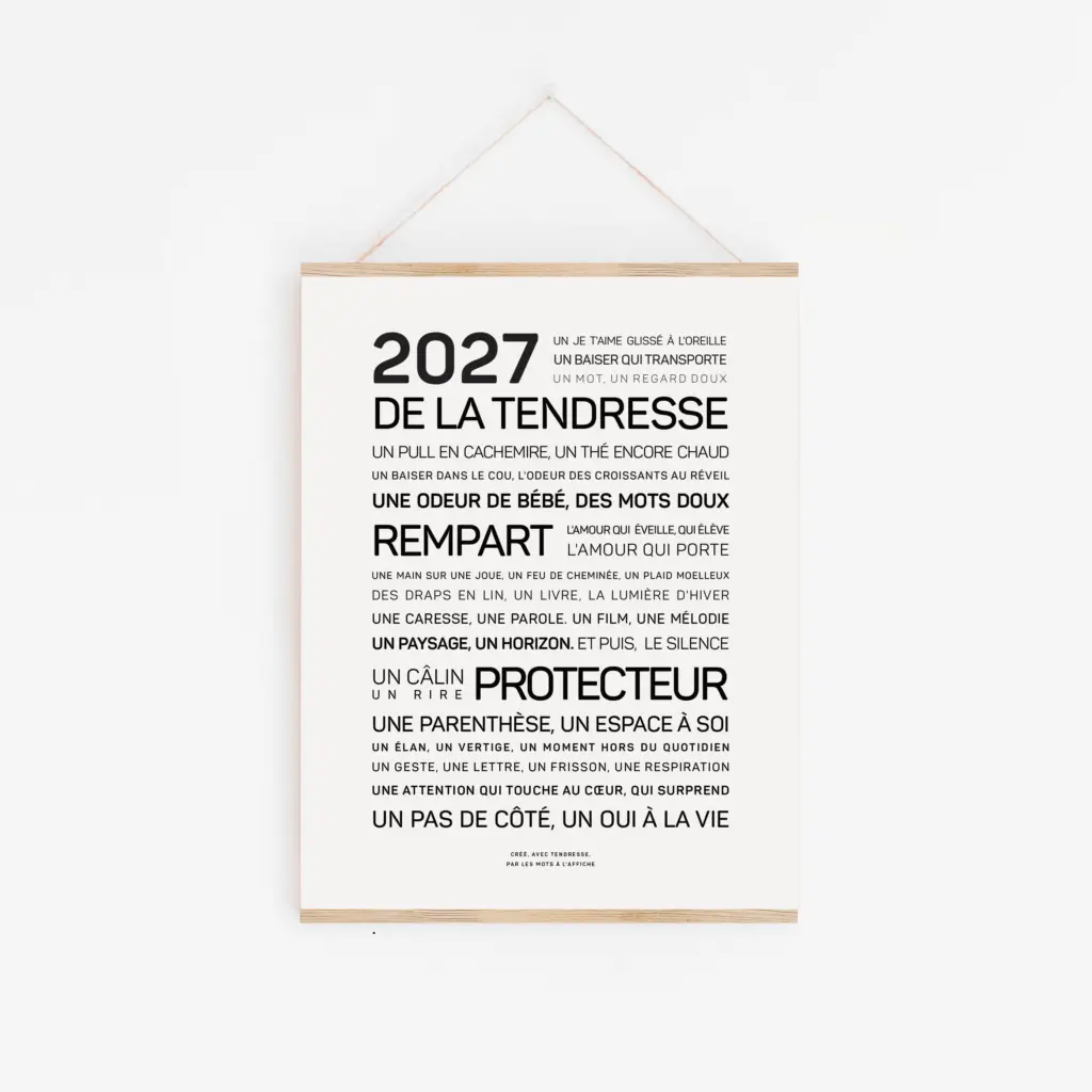 Affiche minimaliste comportant un texte en français commençant par « 2026, BONNE ANNÉE » et énumérant des éléments et des émotions joyeuses en caractères gras et normaux, accrochée à un mur blanc.