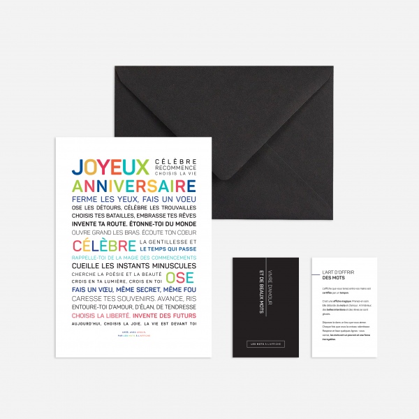 La carte "Joyeux anniversaire (couleurs)" comporte un texte d'anniversaire coloré en français, est accompagnée d'une enveloppe noire et de deux petites cartes d'information, le tout présenté sur un fond clair.