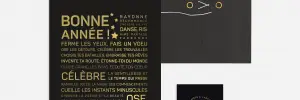 Le set Letter press : Bonne année comprend une chemise noire avec fermeture par cordon, une carte de texte en français noir et or, ainsi qu'une petite carte illustrée d'un chat doré, le tout sur fond blanc.