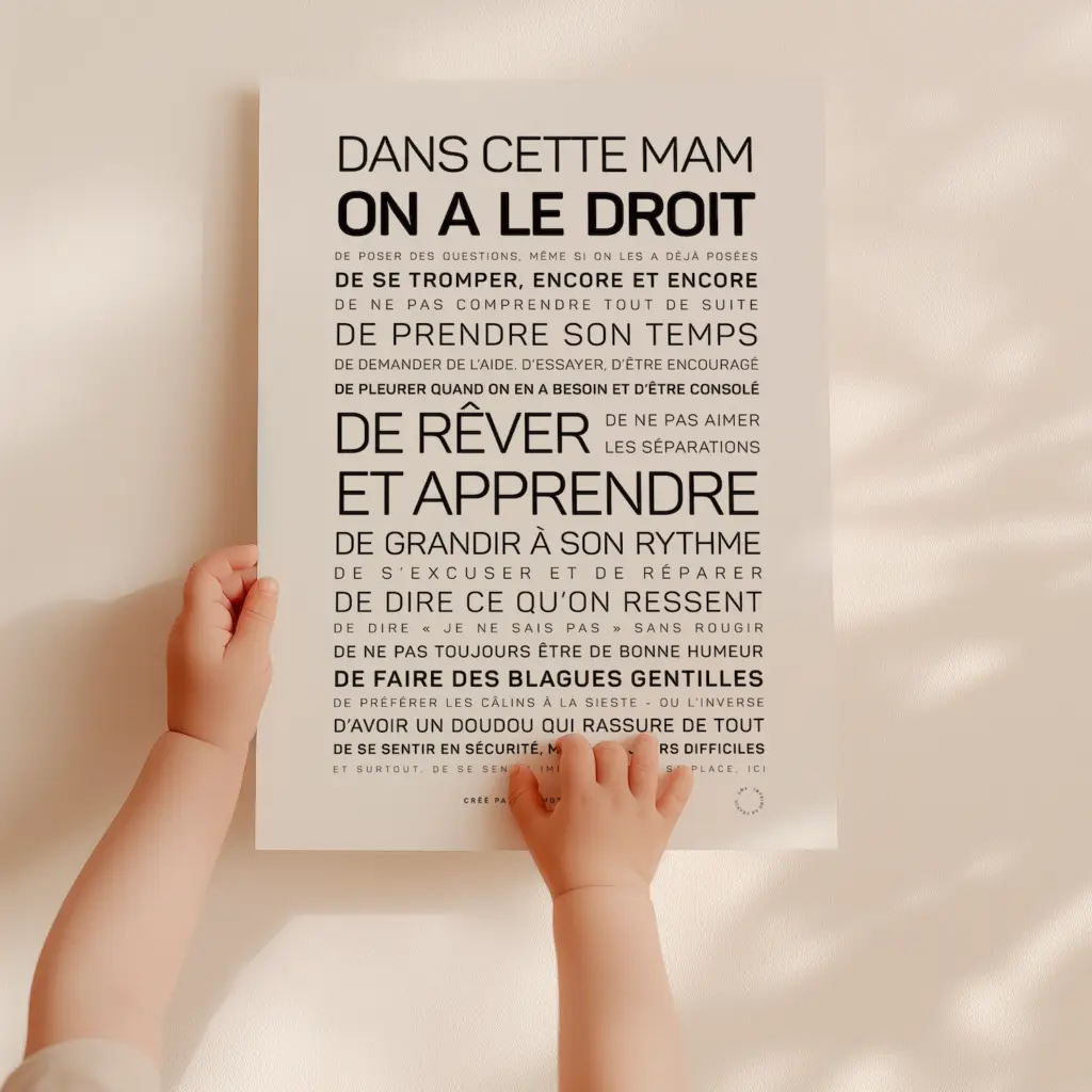 Les mains d'un bébé tiennent l'affiche « Dans cette MAM, on a le droit », sur laquelle figurent des messages d'encouragement et des droits tels que celui d'apprendre, de rêver et d'exprimer ses émotions, écrits en caractères gras et normaux, en français.